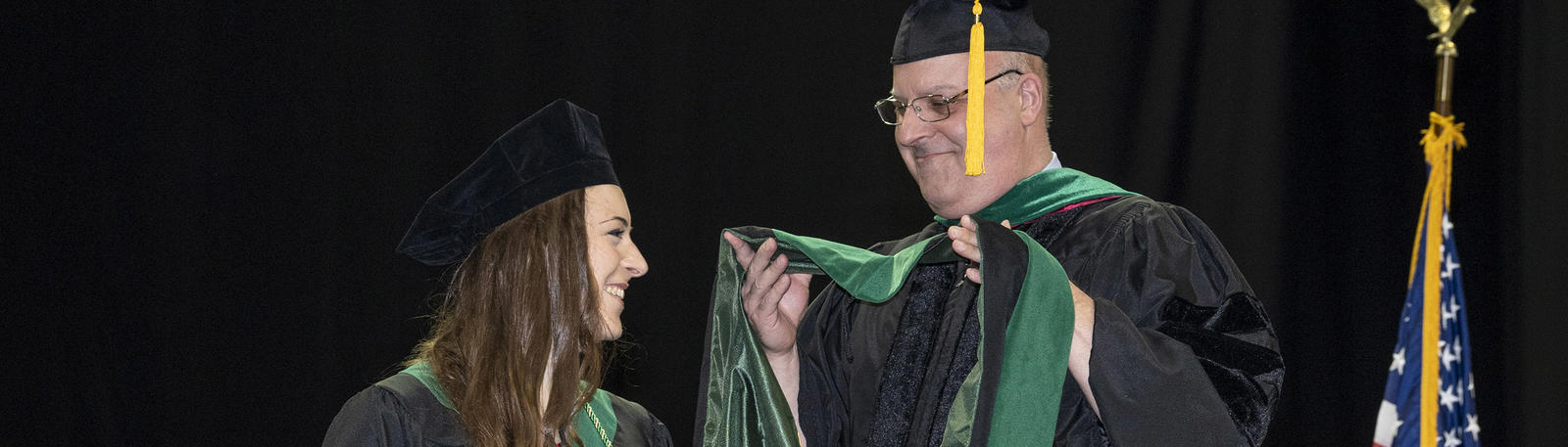 photo of a faculty member and graduate at commencement