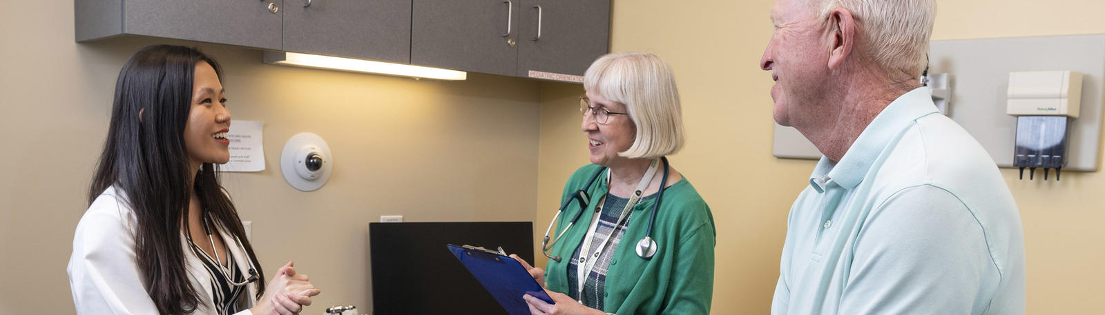 photo of a medical student, faculty member, and patient in an exam room