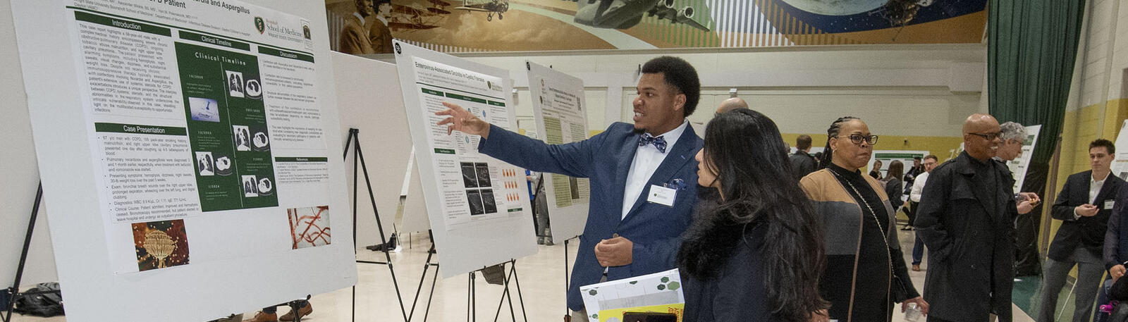 photo of research symposium attendees looking at posters