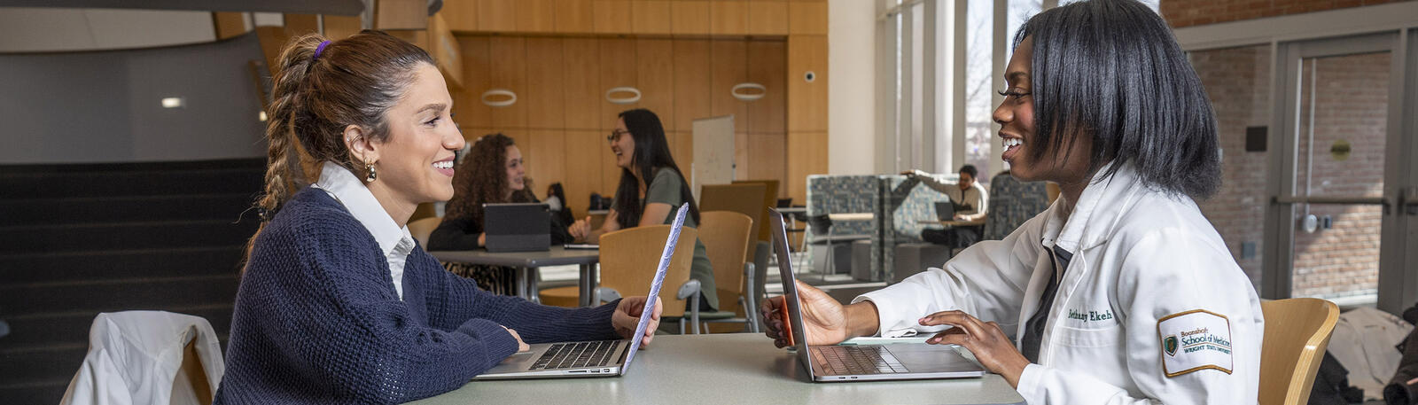 photo of students sitting at a table in white hall