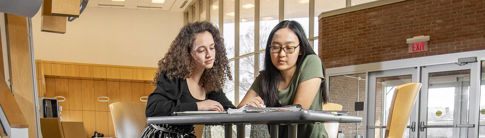 photo of students sitting at a table in white hall