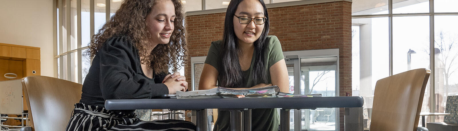 photo of students sitting at a table in white hall