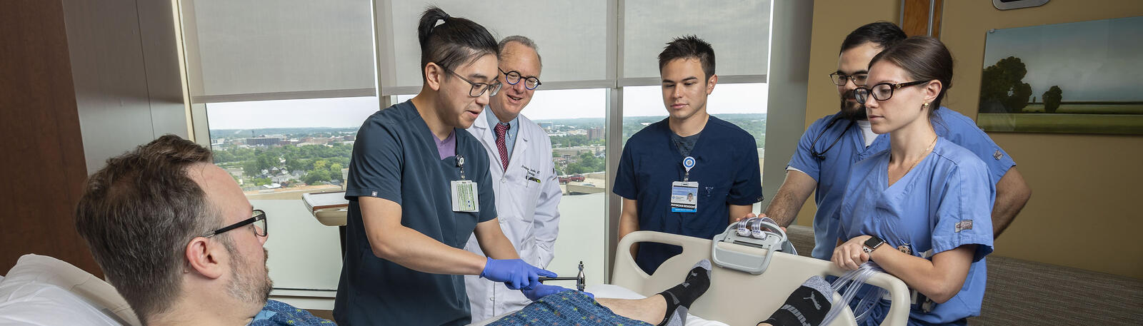 photo of a professor, students, and a patient