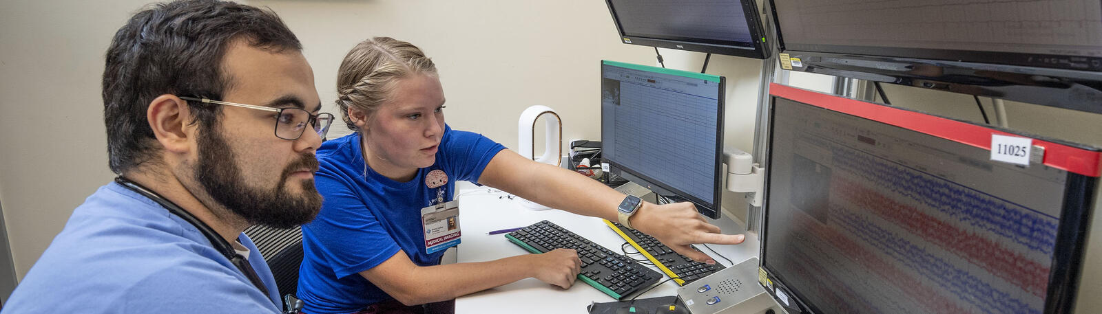 photo of two students looking at a monitor