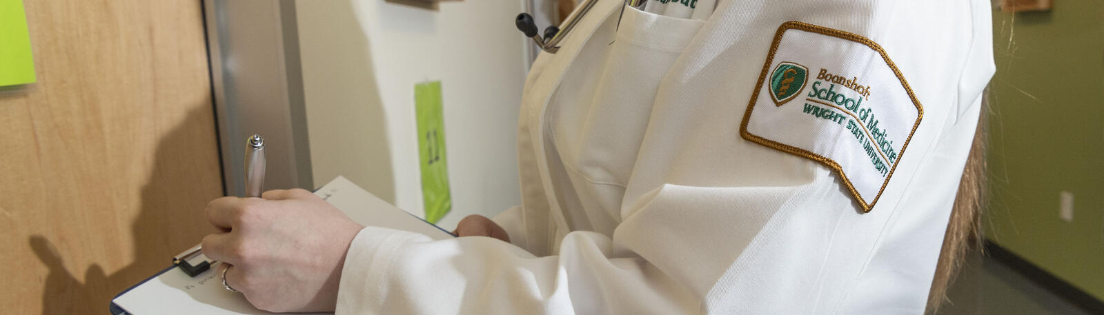 photo of resident holding a clipboard outside of an exam room